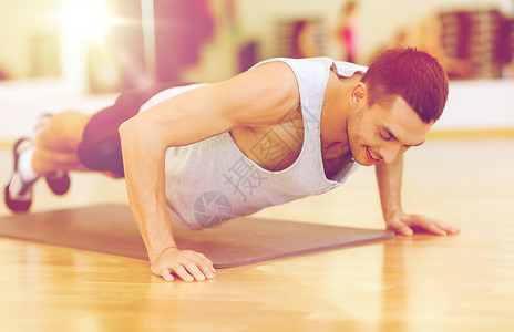 健身,运动,训练,健身房生活方式的微笑的男人健身房俯卧撑图片
