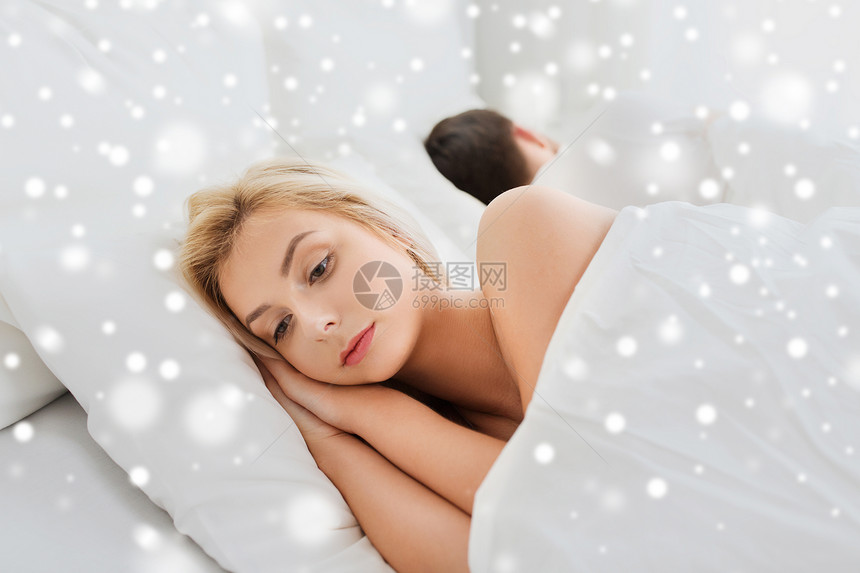 人健康睡眠障碍的夫妇躺家里的床上,轻的女人因雪而失眠图片