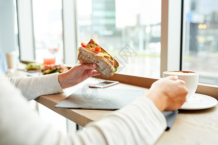 食物,晚餐人们的女人吃三文鱼,帕尼尼三明治,西红柿奶酪,喝咖啡午餐餐厅图片