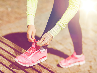 运动,健身,运动生活方式的跑步妇女系鞋带运动鞋图片