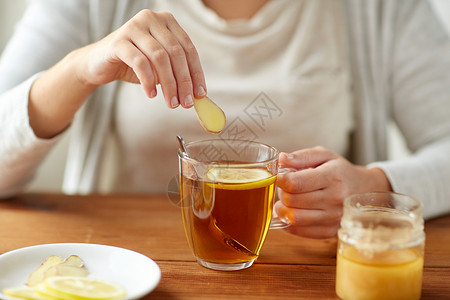健康传统医学民族科学木桌上用柠檬蜂蜜生姜喝茶的病妇高清图片