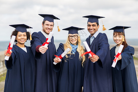 教育,毕业人的群快乐的国际学生迫击炮板学士学位礼服与文凭纸张高清图片素材