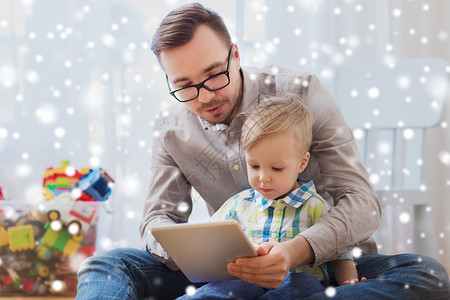 家庭,童,父亲,技术人的快乐的父子与平板电脑电脑家里玩雪图片