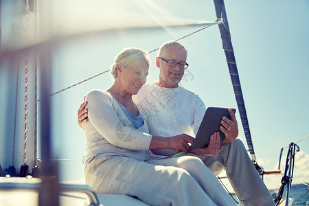 航海,技术,旅游,旅游人的快乐的老夫妇与平板电脑帆船游艇甲板漂浮海上图片
