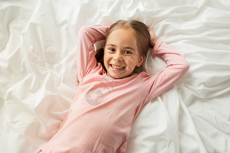 人,孩子睡前快乐的小女孩躺家里的床上图片