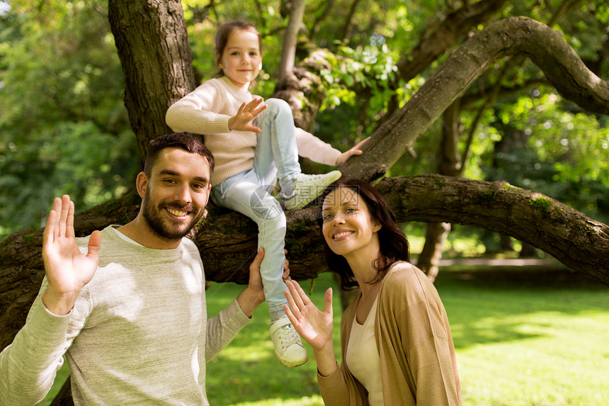 家庭,父母,收养人的快乐的母亲,父亲小女孩夏季公园挥手图片