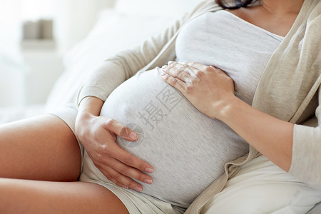 怀孕,休息,人期望密切孕妇躺床上,触摸她的肚子家里背景图片