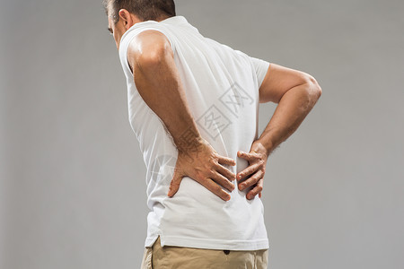 肾绞痛人,医疗保健问题密切的人遭受痛苦的背部灰色背景背景