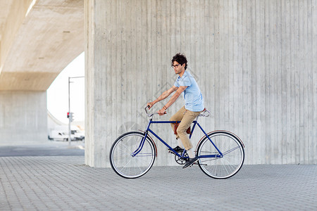 人,风格,休闲生活方式轻的时髦男子骑固定齿轮自行车城市街道图片