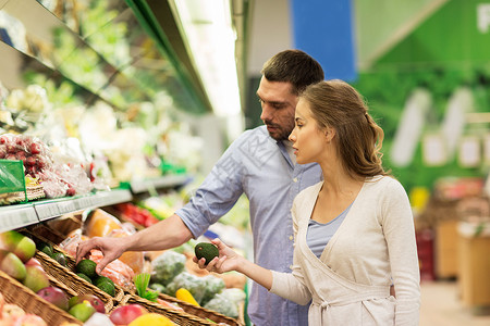 购物,食品,销售,消费主义人们的幸福的夫妇购买鳄梨杂货店超市图片