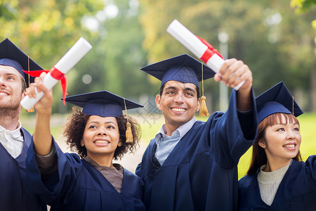 教育毕业人的群快乐的国际学生穿着灰浆板学士服,毕业证书庆祝成功大学高清图片素材