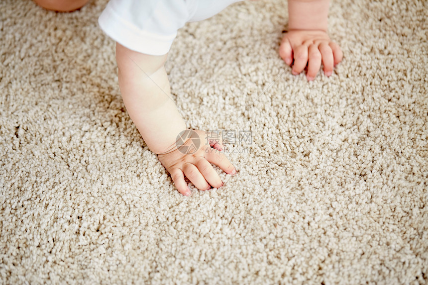 童,婴儿人的婴儿地板地毯上爬行的手图片
