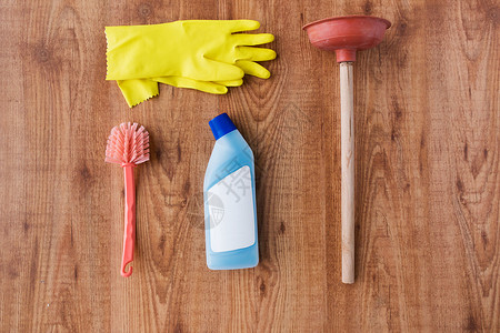 清洁用品,家务,家务家庭柱塞,橡胶手套刷子与洗涤剂木制背景图片