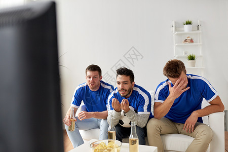 友谊,运动,人娱乐活动的男朋友球迷带着啤酒家里看足球图片