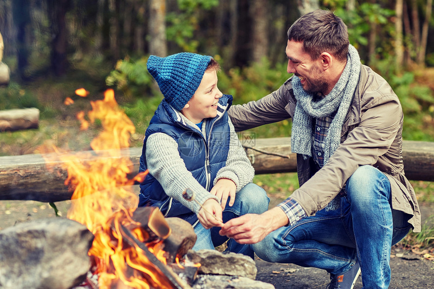 野营,旅游,远足,家庭人的快乐的父亲儿子烤棉花糖超过篝火图片