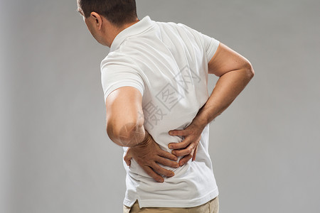 养肾人,医疗保健问题密切的人遭受痛苦的背部灰色背景特写患背痛的人背景
