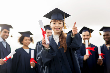教育毕业手势人的群快乐的国际学生穿着灰浆板学士服,毕业证书竖大拇指文凭的快乐学生竖大拇指纸张高清图片素材