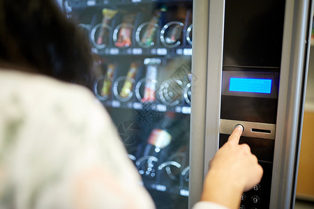 销售,技术消费妇女按按钮自动售货机操作板女人自动售货机上按按钮背景图片