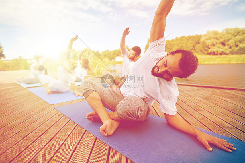 健身,运动,瑜伽健康的生活方式群人河流湖泊泊位上锻炼伸展群人户外瑜伽练图片