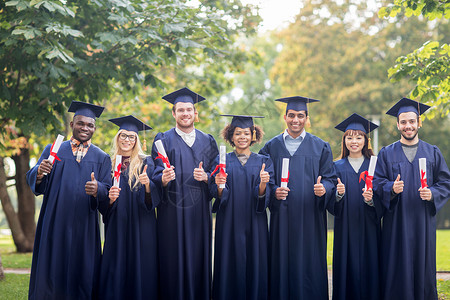 教育毕业手势人的群快乐的国际学生穿着灰浆板学士服,毕业证书竖大拇指文凭的快乐学生竖大拇指学校高清图片素材