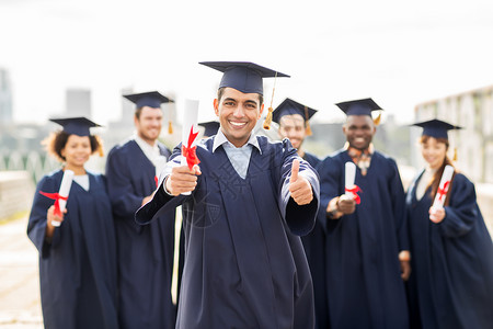 教育毕业手势人的群快乐的国际学生穿着灰浆板学士服,毕业证书竖大拇指文凭的快乐学生竖大拇指幸福的高清图片素材