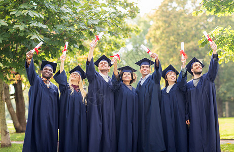 教育毕业人的群快乐的国际学生穿着灰浆板学士服,毕业证书庆祝成功文凭的迫击炮板上快乐的学生胜利高清图片素材