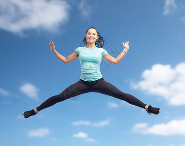 快乐微笑运动的女人空中跳跃图片
