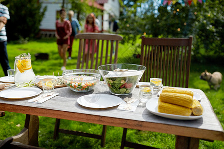 假期,饮食,用餐时间食物人们来提供桌子与晚餐夏季花园聚会人们夏天的花园里带着食物来吃饭背景图片