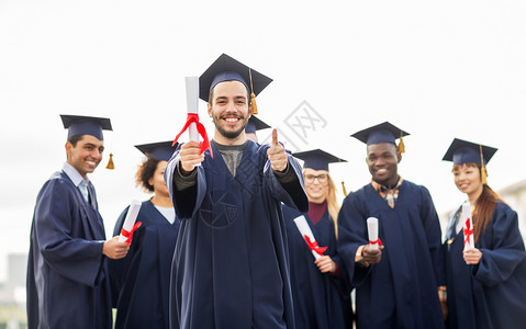教育毕业手势人的群快乐的国际学生穿着灰浆板学士服,毕业证书竖大拇指文凭的快乐学生竖大拇指黑色高清图片素材