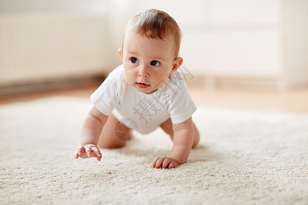 地上爬的小婴儿童,童人的小男孩女孩家里地板上爬行穿着尿布的小婴儿家里地板上爬行背景
