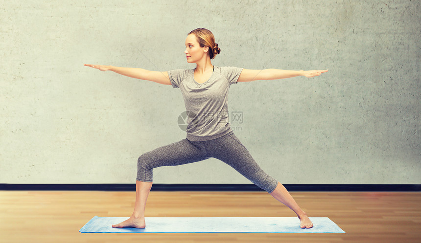 健身,运动,人健康的生活方式妇女瑜伽战士姿势垫子上的房间健身房背景女人垫子上瑜伽战士的姿势图片