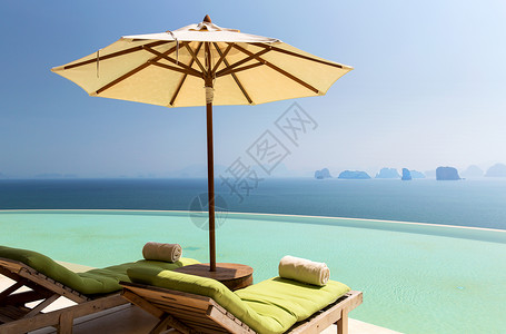 旅行,暑假,旅游豪华美丽的风景无限边缘游泳池与阳伞太阳床为两人海边无限游泳池,海洋中阳伞太阳床背景图片