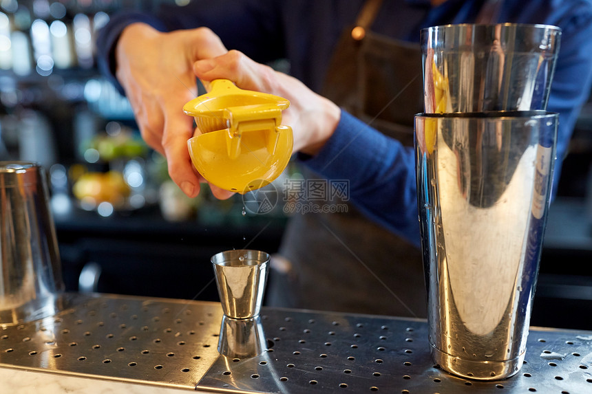 酒精饮料,人豪华调酒师与瓶柑橘压榨机挤压果汁吉格准备鸡尾酒酒吧酒保酒吧把果汁挤进吉格图片