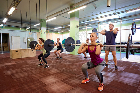健身,运动,训练,锻炼生活方式的群杠铃的人健身房蹲下群人健身房用杠铃训练图片