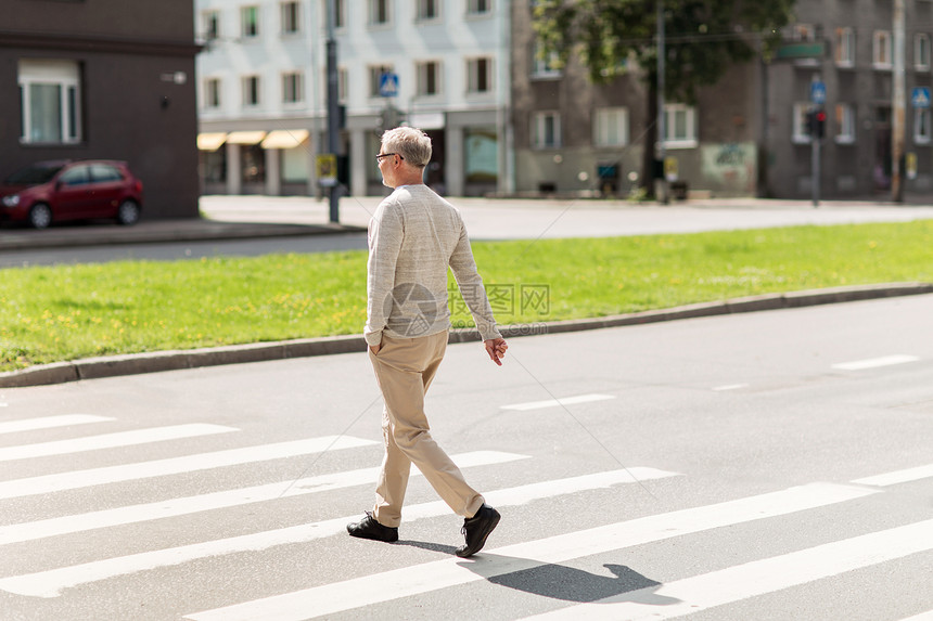 休闲人的老人走夏季城市人行横道老人沿着城市人行横道行走图片