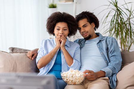 人,家庭休闲的幸福的夫妇与爆米花家里看电视幸福的夫妇家里看电视吃爆米花图片