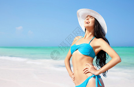 暑假,假期,旅行人们的微笑的轻女人穿着比基尼泳衣太阳帽海滩上的海洋蓝天背景夏天海滩上戴着太阳帽的轻女人微笑背景图片