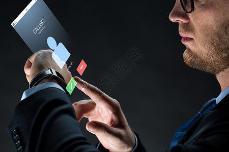商业,人,通信现代技术商人与智能手表来电虚拟投影黑色背景用智能手表商人图片