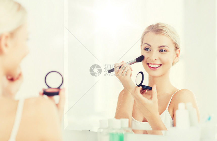 美丽,化妆,化妆品,早晨人的微笑的轻女人用化妆刷涂腮红,家里的浴室照镜子浴室里化妆刷腮红的女人图片