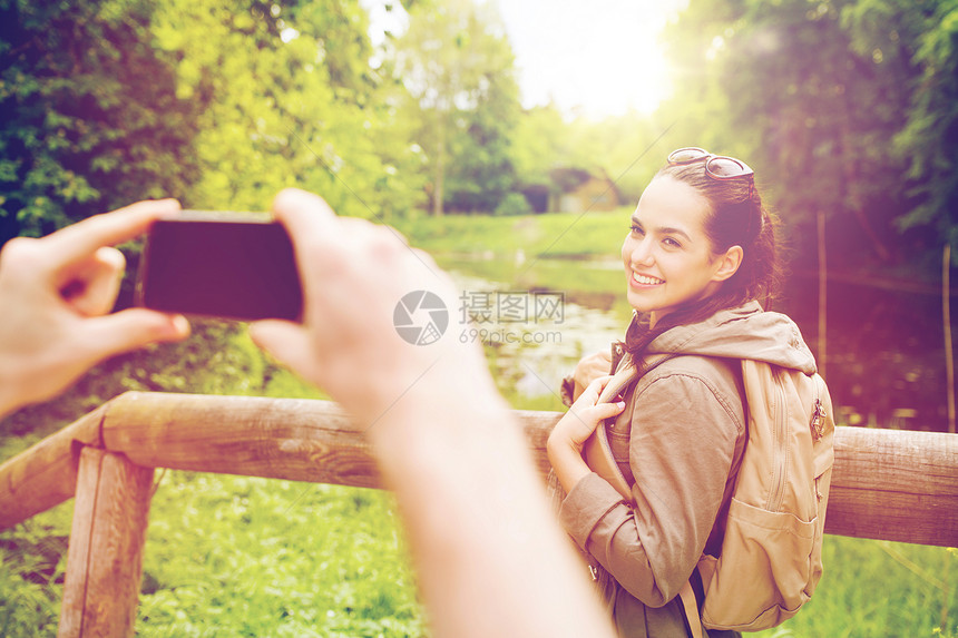 旅行,徒步旅行,背包,旅游人的微笑的夫妇与背包拍摄智能手机自然界夫妇用智能手机拍摄背包图片
