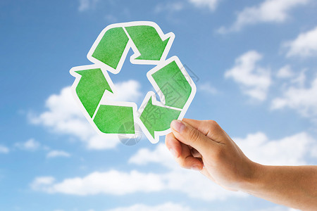 垃圾处理环境生态蓝天云层背景下,手握绿色回收标志用绿色回收标志天空上手图片