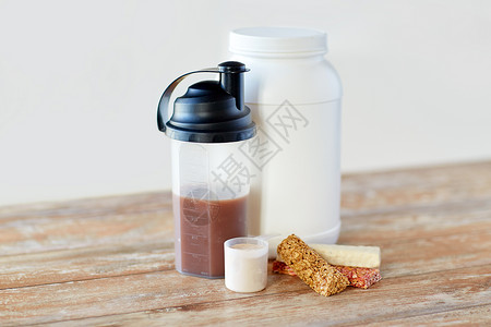 运动营养,健身饮食食物罐子,蛋白质瓶木桌上的木条食物运动营养添加剂桌子上图片