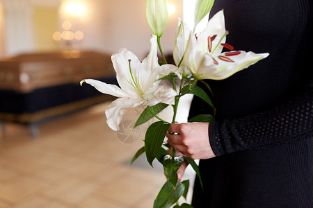 人们哀悼的教堂的葬礼上用白色百合花棺材特写女人葬礼上用百合花靠近女人图片