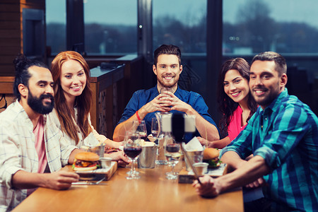 休闲,技术,友谊,人假日的快乐的朋友餐厅用智能手机自拍棒吃饭拍照朋友们餐厅用智能手机自拍背景图片