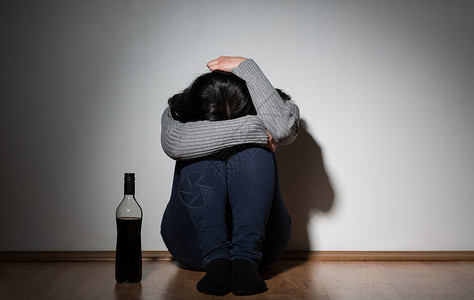 酗酒,抑郁人们的观念快乐的女人家里哭着喝瓶酒家里瓶酒的女人哭背景图片