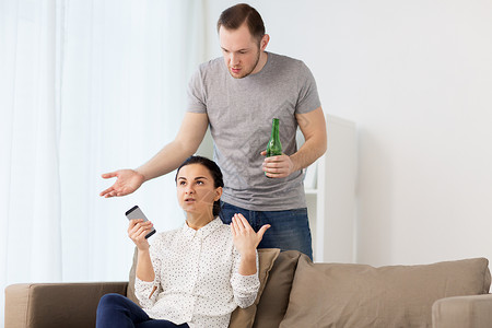 人,关系困难冲突男人喝啤酒,女人用智能手机家里争论夫妇家里吵架图片