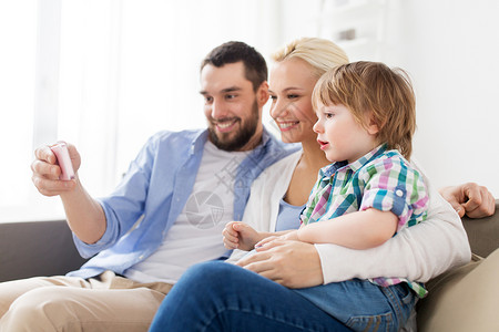 家庭,技术人的快乐的母亲,父亲小男孩家里智能手机家里智能手机的幸福家庭图片