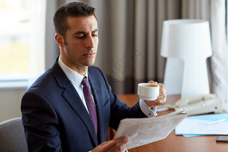 商业,人民大众媒体的商人阅读报纸酒店房间喝咖啡商人读报纸喝咖啡打破高清图片素材