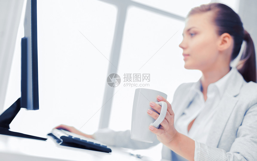 商业,办公室,学校教育女商人与电脑办公室喝咖啡办公室里电脑的女商人图片