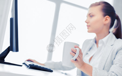 商业,办公室,学校教育女商人与电脑办公室喝咖啡办公室里电脑的女商人图片